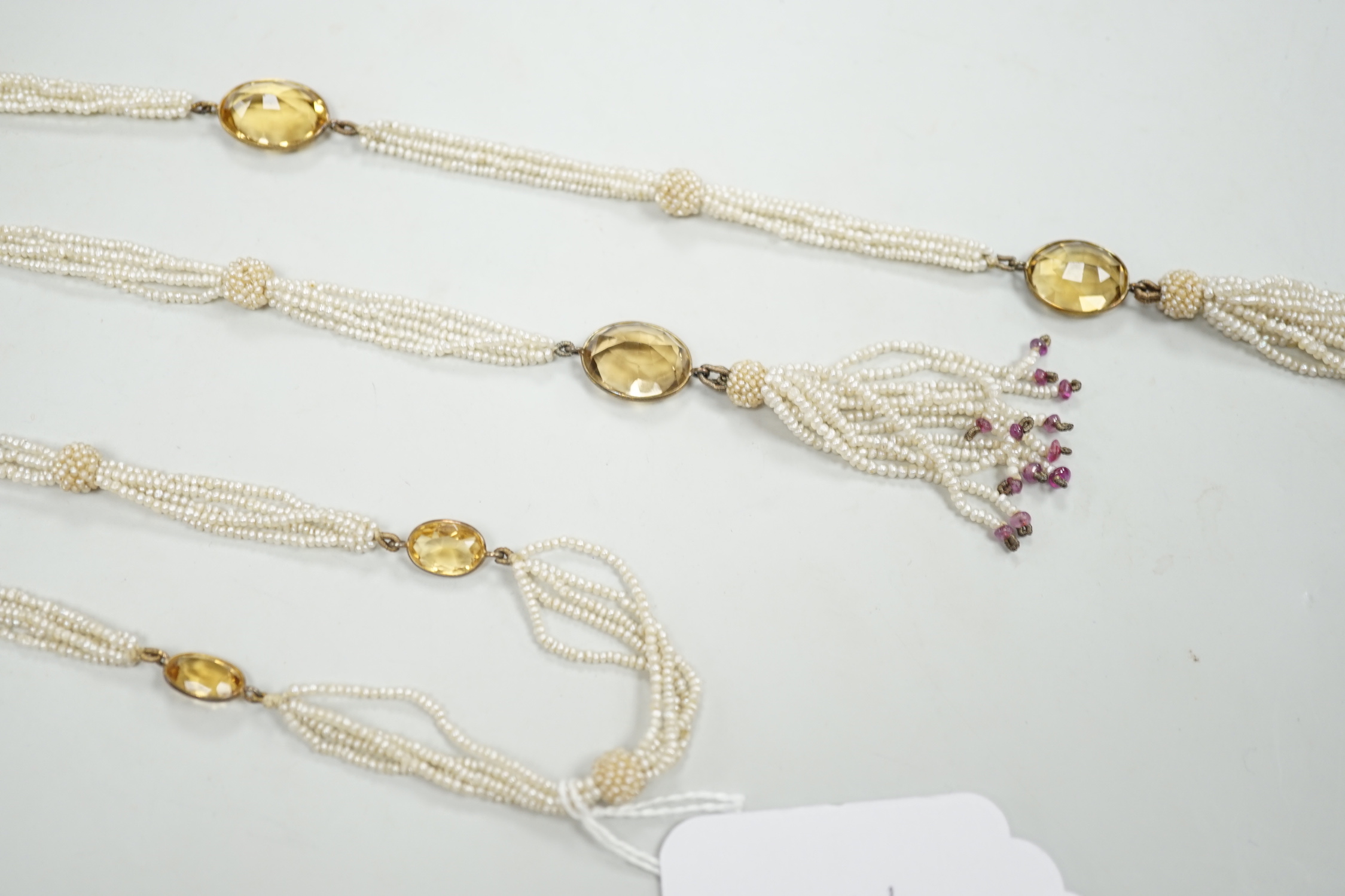 A 19th century Indian multi strand seed pearl and oval cut citrine set long necklace, with gem set tassel drops, 166cm.